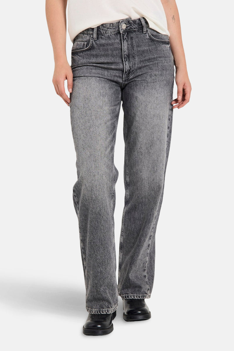 Jean droit en denim gris foncé de FREEQUENT, coupe décontractée et chaussures noires visibles.
