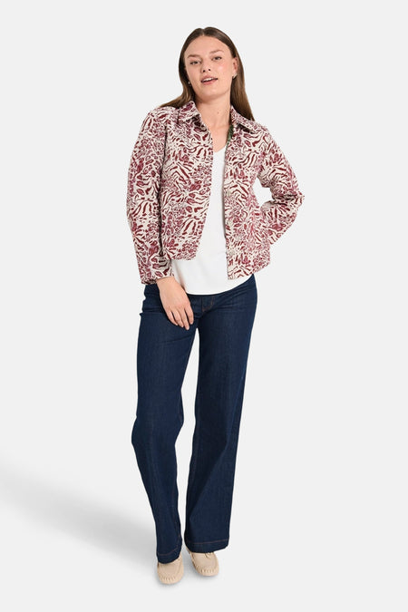 Korte meerkleurige jas van FREEQUENT, gedragen over een wit T-shirt en een blauwe jeans, met een paisley-patroon.