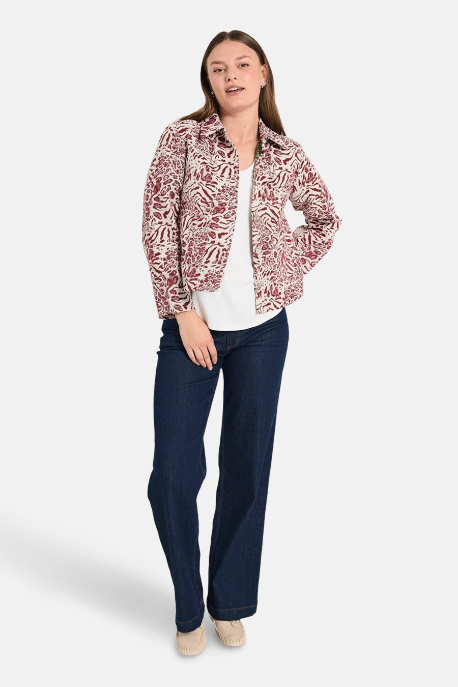 Korte meerkleurige jas van FREEQUENT, gedragen over een wit T-shirt en een blauwe jeans, met een paisley-patroon.