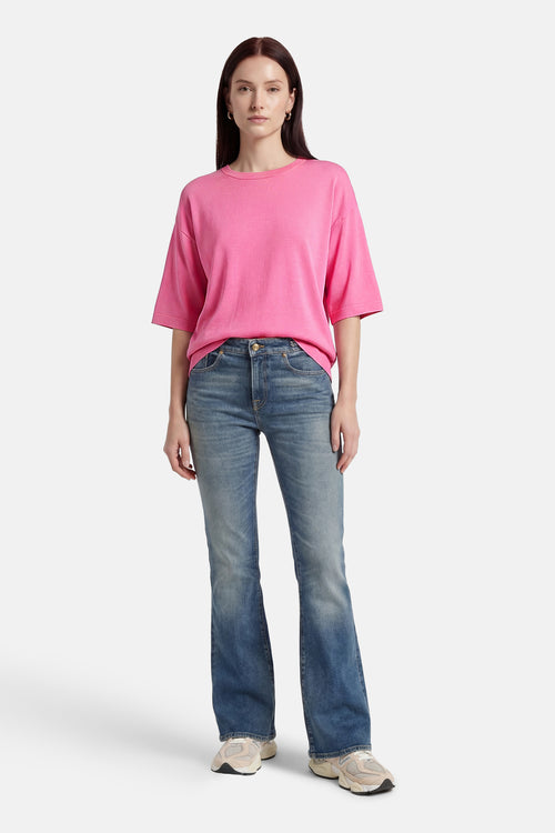 Pull rose à col rond de FREEQUENT, porté avec un jean bleu et des baskets de sport.