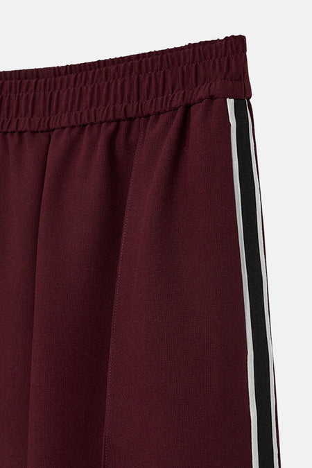 Bordeaux broek van FREEQUENT met zwart-witte zijstrepen, elastische tailleband.
