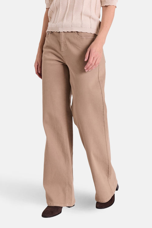 Jean coloré beige de FREEQUENT, coupe droite ample, porté avec un pull en maille beige.
