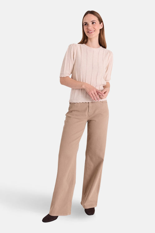 Jeans colorés beige de FREEQUENT, coupe droite et jambes larges, portés avec un pull en tricot et des chaussures marron foncé.
