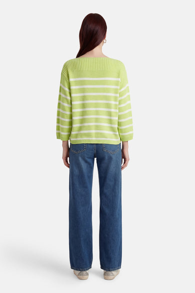 Pull vert à rayures blanches de FREEQUENT, porté avec un jean bleu large et des chaussures argentées, vue de dos.
