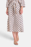 Jupe midi beige à pois bleu marine de FREEQUENT, portée avec une ceinture à la taille et des sandales.