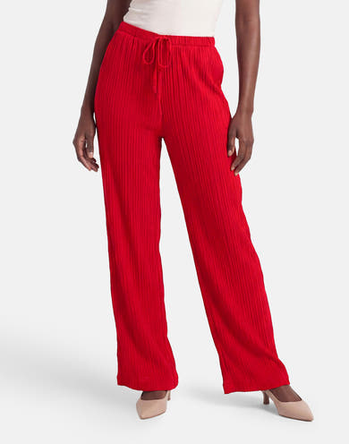 Pantalon plissé rouge de FREEQUENT à taille coulissée, porté avec un haut blanc et des talons nude.