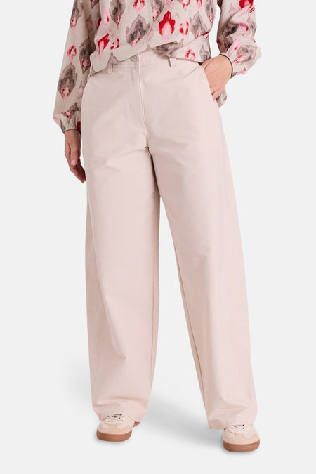 Jeans coloré beige de FREEQUENT, coupe ample, porté avec un chemisier à motifs.
