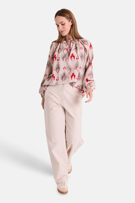 Jean coloré beige de FREEQUENT, ample et décontracté, porté avec un chemisier à motif.
