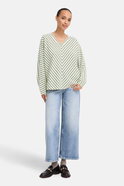 Beige sweater met groene strepen van B.YOUNG, gedragen met een wijde jeans en zwarte loafers.