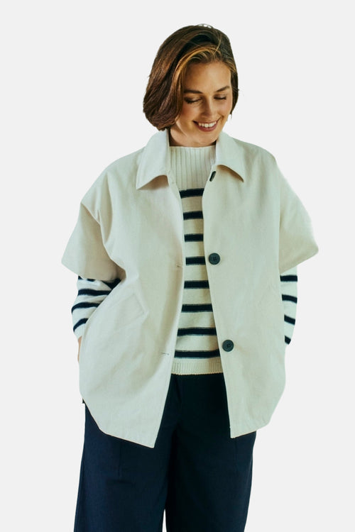 Veste courte beige de FREEQUENT avec des boutons foncés, portée sur un pull rayé et un pantalon foncé.