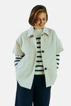 Veste courte beige de FREEQUENT avec des boutons foncés, portée sur un pull rayé et un pantalon foncé.