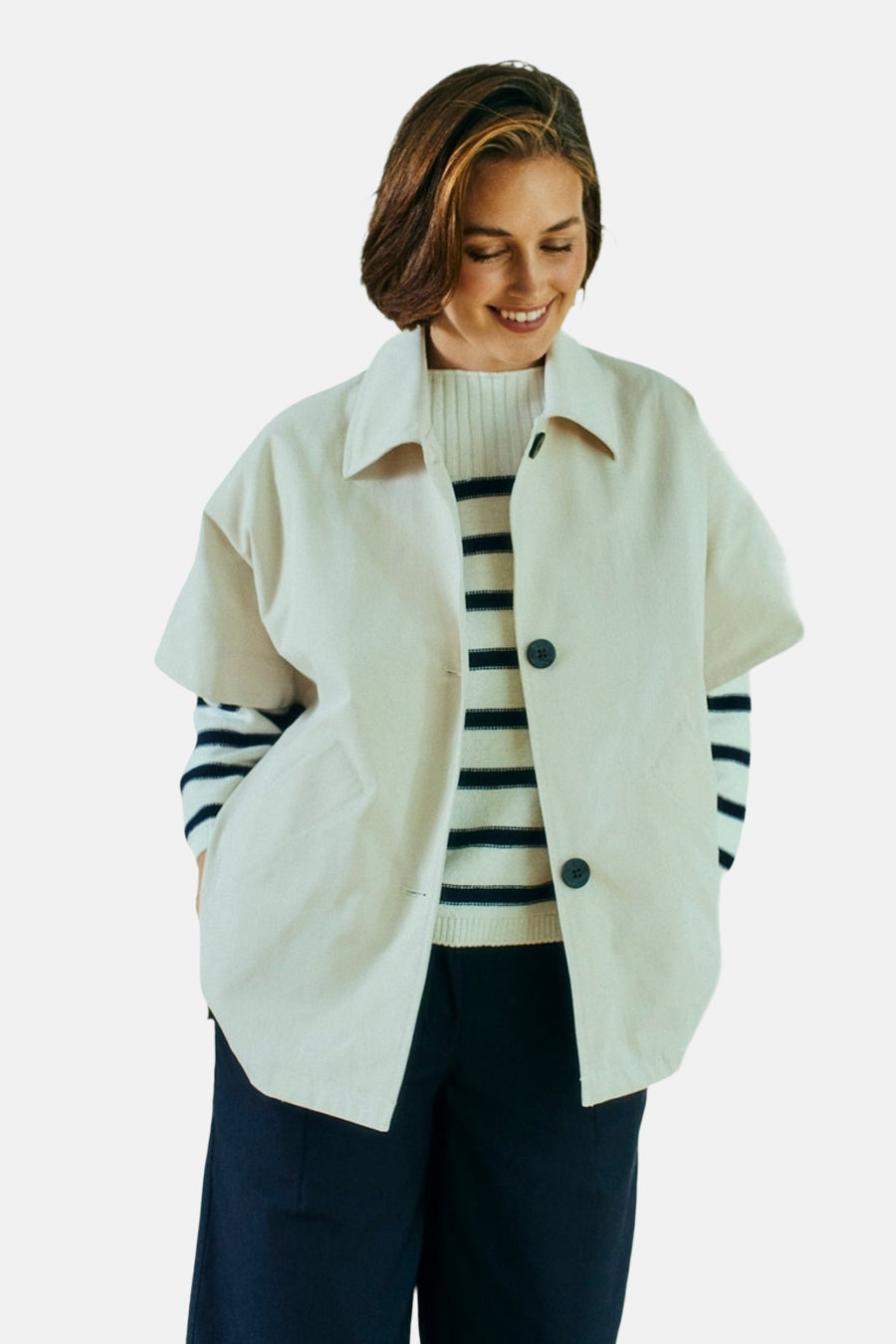 Veste courte beige de FREEQUENT avec des boutons foncés, portée sur un pull rayé et un pantalon foncé.