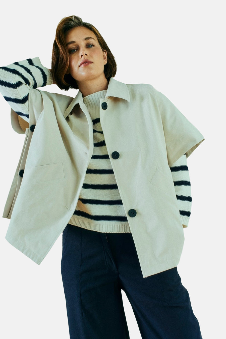 Veste courte beige de FREEQUENT, boutonnée avec un motif rayé visible et pantalon bleu marine.
