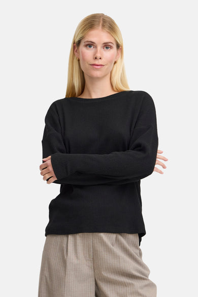 Zwarte T-shirt met lange mouwen van B.YOUNG, in ribgebreide stof, gedragen met een broek met verticale strepen.