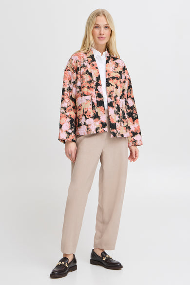 Multikleurige blouse met lange mouwen van B.YOUNG, gedragen met een bloemenjasje en een beige broek.