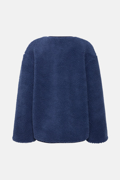Blauwe teddyjas van B.YOUNG, getextureerd en warm, van achteren gezien.