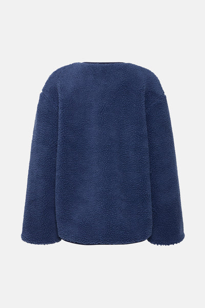 Blauwe teddyjas van B.YOUNG, getextureerd en warm, van achteren gezien.