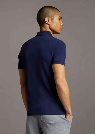Polo bleu marine de LYLE & SCOTT, porté avec un pantalon de survêtement gris, vue arrière.
