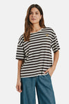 Multicolored short-sleeve striped T-shirt with brown and cream horizontal stripes, featuring a small sunflower patch on the chest, worn with blue jeans in a front lifestyle view.