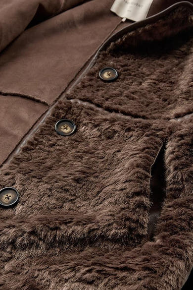 Détail de la veste longue taupe FREEQUENT avec doublure imitation fourrure et boutons.