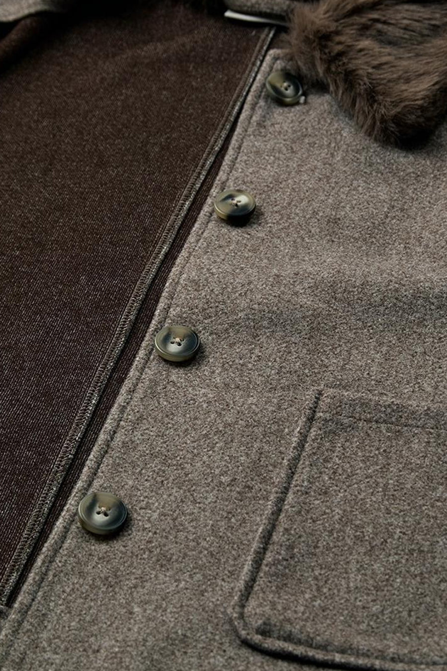 Gros plan sur une veste taupe FREEQUENT à boutons et col bordé de fourrure.