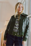Veste verte en simili-cuir brillant par FREEQUENT, vue de face, portée avec un pull à motifs géométriques et jeans foncés