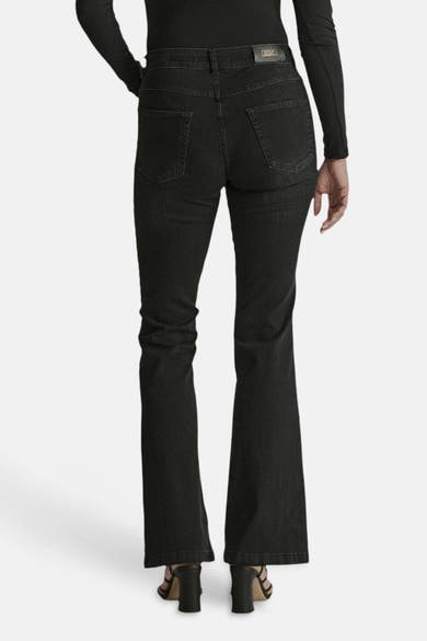 Black flared denim jeans by JADE, back view with classic stitching and straight-to-flare leg, worn with black top and heels