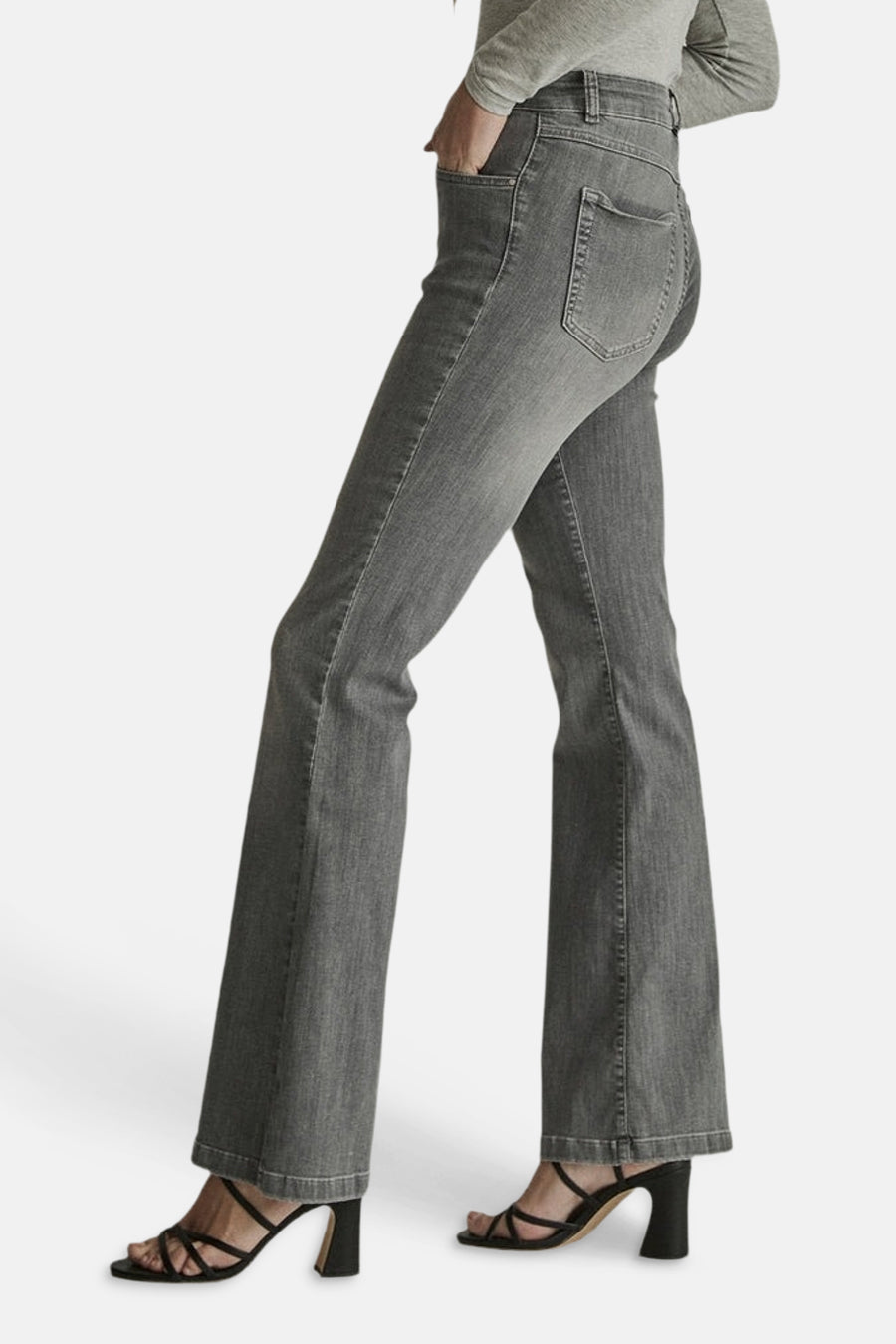 Light grey flared denim jeans by JADE, side view showing slim fit to wide leg, worn with olive top and black strappy heels