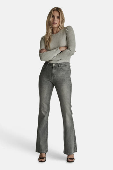 Light grey flared jeans by JADE, featuring a high waist, classic five-pocket design, and subtle fade, worn with a long-sleeve top and strappy sandals in a full front view.