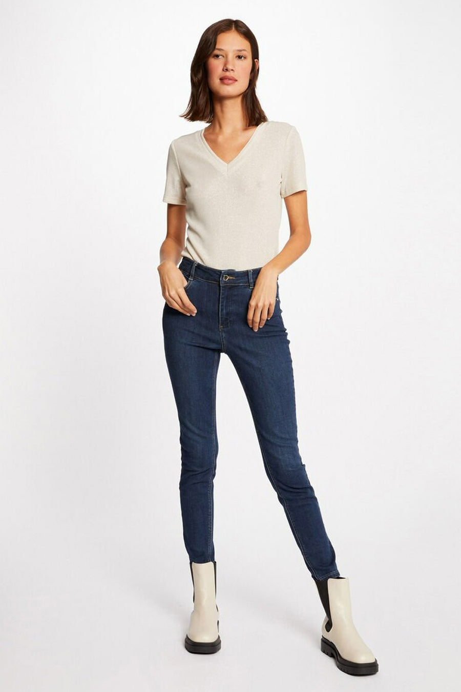 T-shirt beige à manches courtes de Morgan de Toi, porté avec un jean bleu et des bottines blanches.