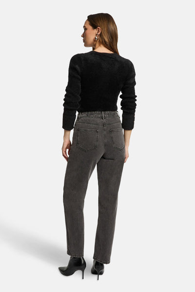 Zwarte V-hals trui van Morgan de Toi, lange pofmouwen, gedragen met een grijze jeans en zwarte enkellaarsjes.