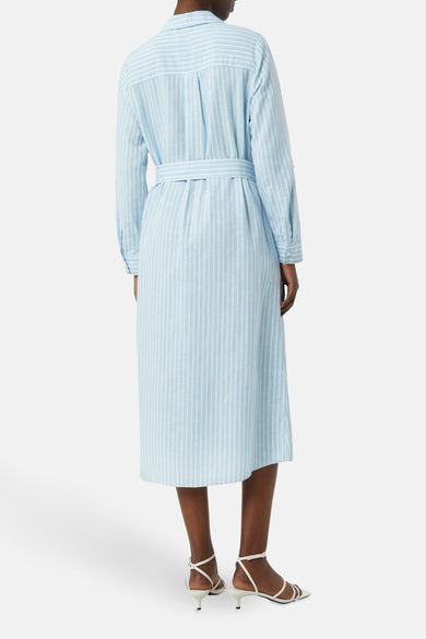 Robe chemise rayée bleu et blanc de COMMA, avec ceinture assortie et chaussures à talons aiguilles blanches.
