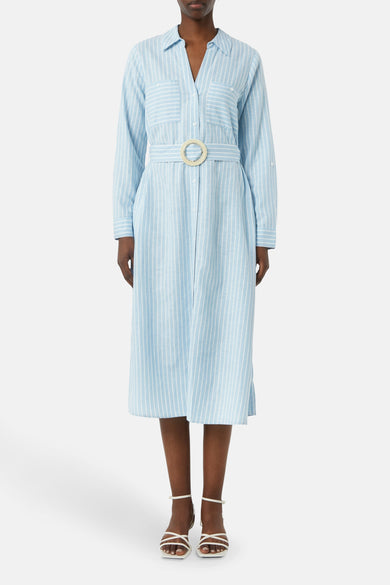 Robe chemise rayée bleu et blanche de COMMA, avec une ceinture décorative à boucle ronde tressée et des sandales blanches.