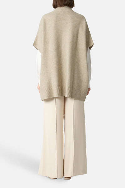 Beige gilet van COMMA, gedragen over een wit overhemd met een crèmekleurige wijde broek.