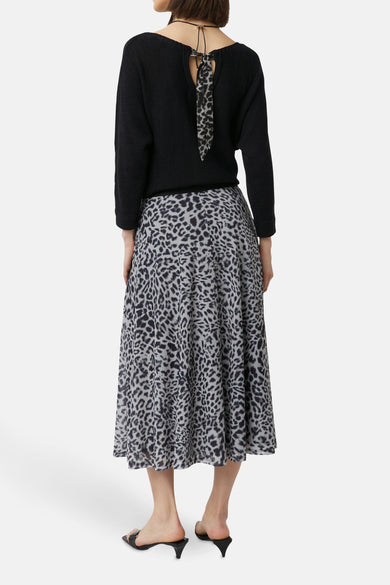 Jupe 3/4 grise à motif léopard de COMMA, avec un haut noir et des chaussures à talons noirs.