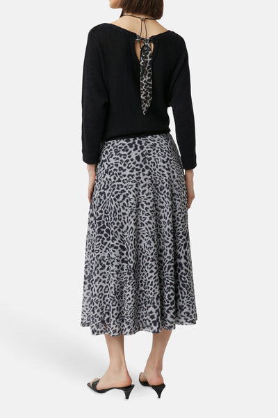 Jupe 3/4 grise à motif léopard de COMMA, avec un haut noir et des chaussures à talons noirs.