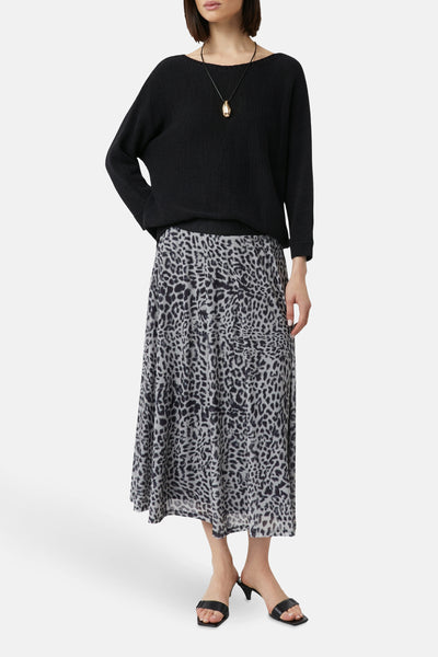 Jupe midi grise à motif animalier de COMMA, portée avec un pull noir et un collier doré.
