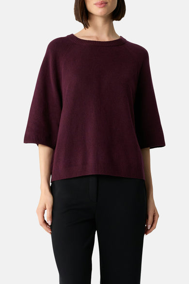 Bordeaux ronde hals trui van COMMA, met wijde korte mouwen en gedragen met een zwarte broek.