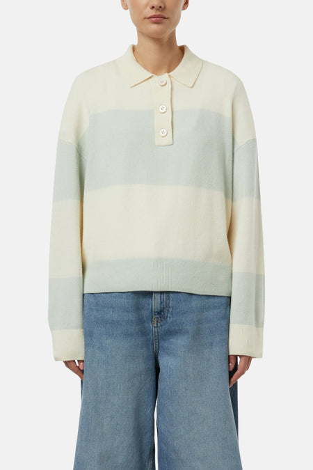 Pull multicolore rayé de COMMA, avec col polo boutonné et manches longues, porté avec un pantalon en jean ample.