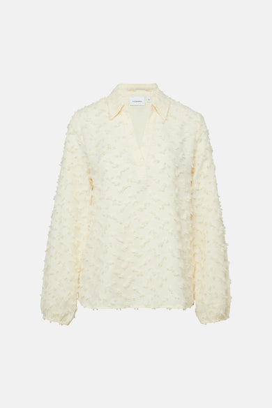 Beige blouse met lange mouwen van COMMA, met reliëftextuur en V-hals, gedragen met een blauwe jeans.