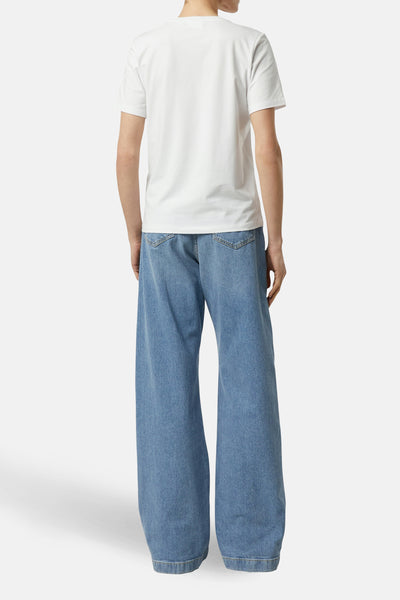Wit T-shirt met korte mouwen van COMMA, gedragen met een lichtblauwe wijde jeans.