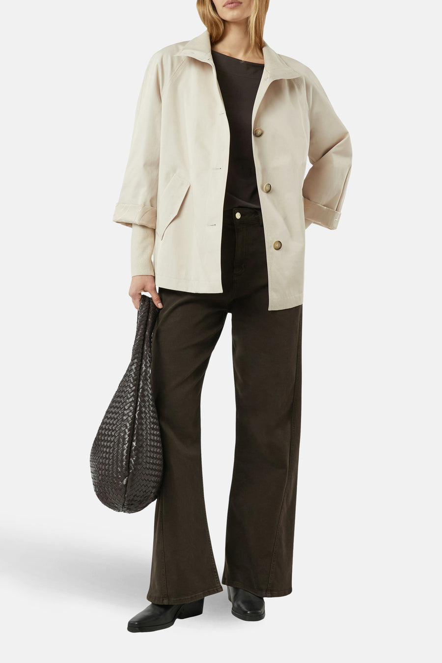 Veste courte beige de COMMA, avec boutons, portée avec un pantalon marron et un sac tressé.