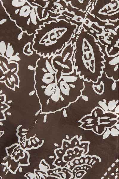 Brown foulard with white floral pattern, close-up view showing intricate design and fabric texture