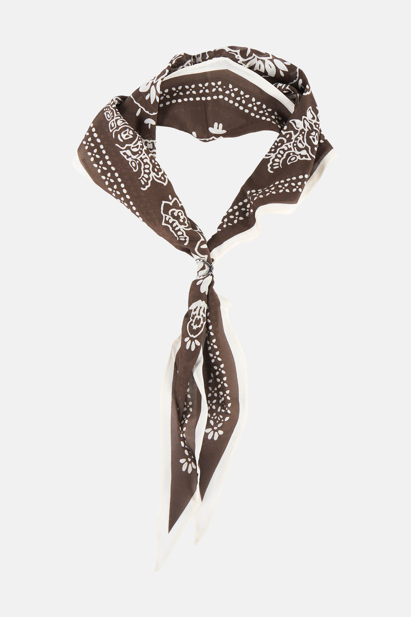 Brown foulard with white floral and dot pattern, tied in knot, showing lightweight fabric texture and white border trim