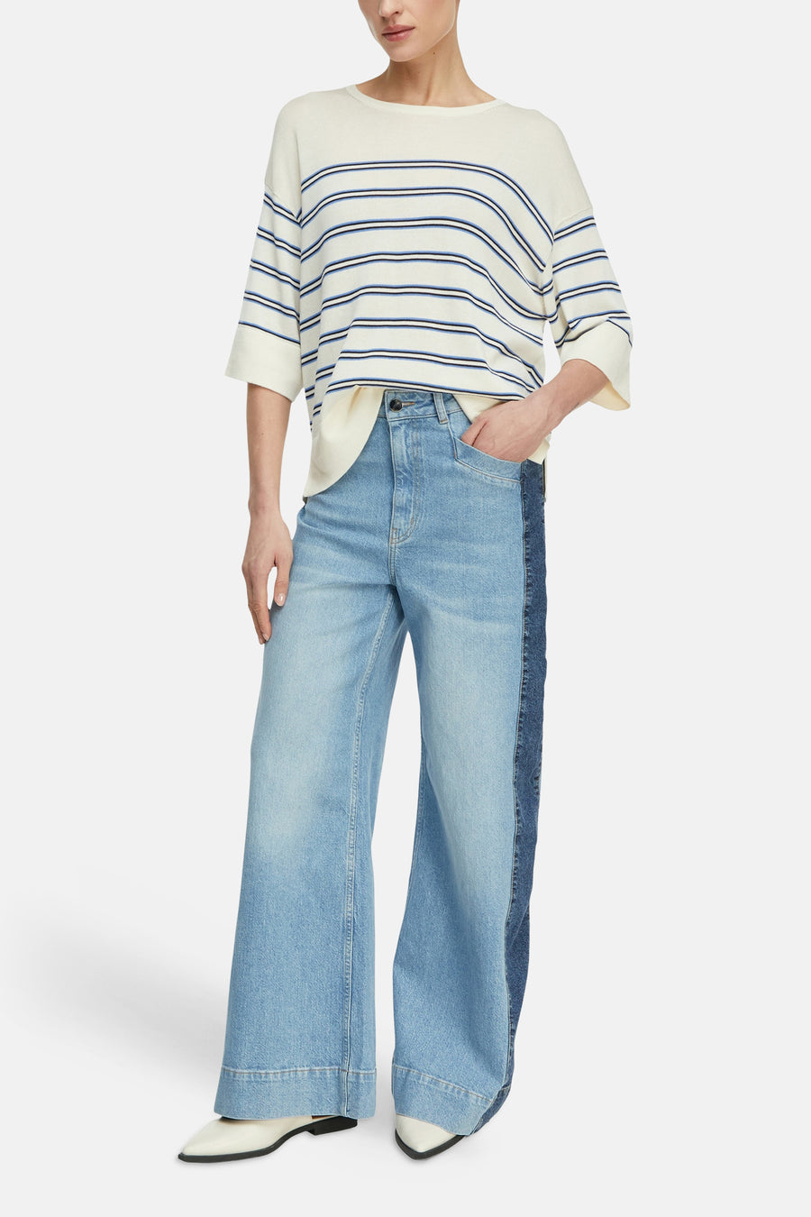Multikleurige gestreepte trui van COMMA, gedragen met een wijde, lichtblauwe jeans.