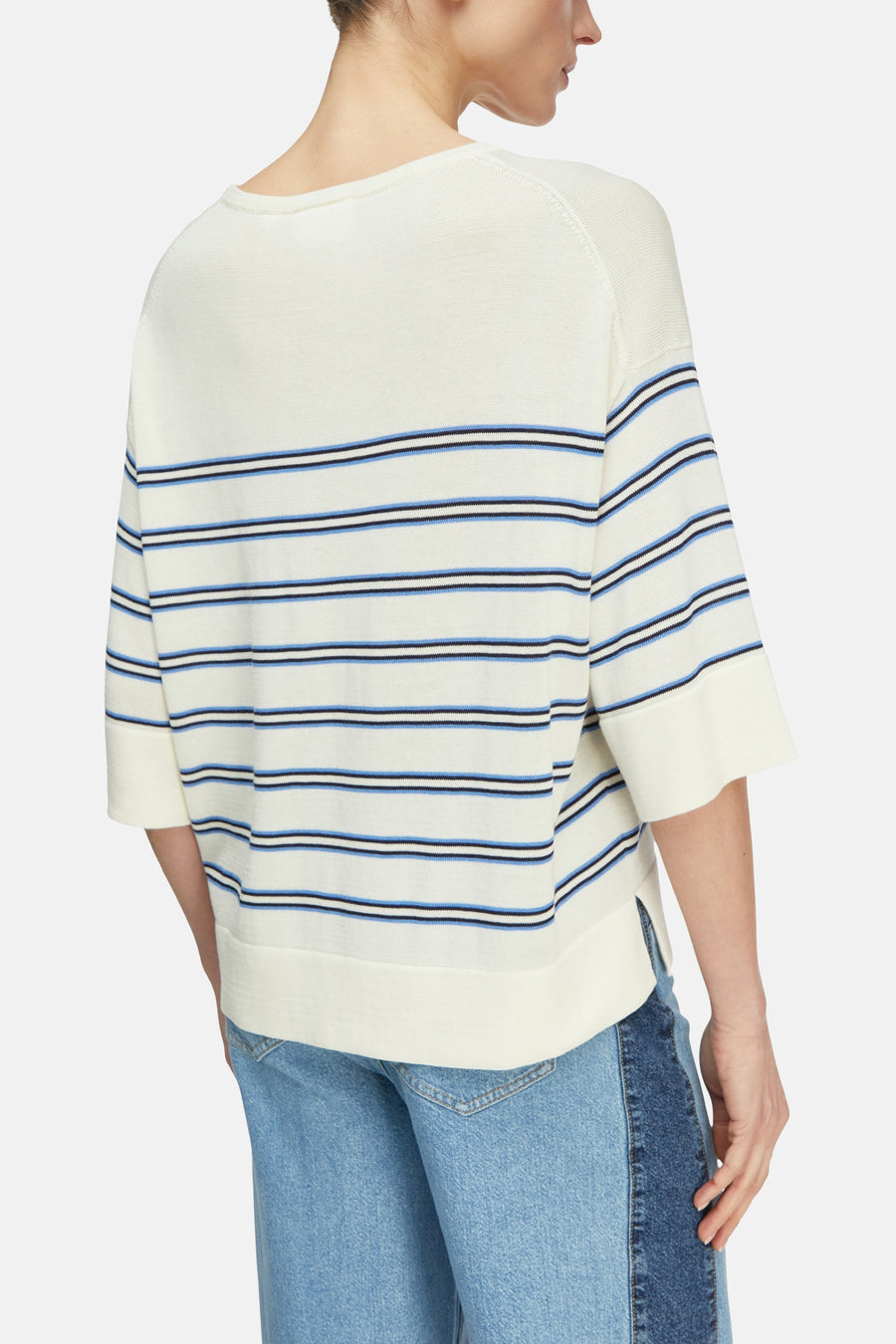 Pull en maille multicolore de COMMA, avec rayures bleues et manches trois-quarts, porté avec un jean.
