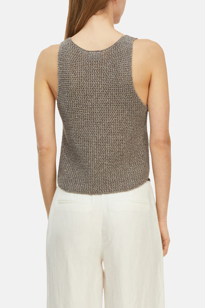 Top sans manches taupe de COMMA en maille ajourée, col rond au dos, porté avec un pantalon blanc.