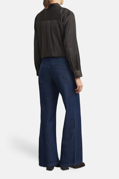 Jean large en denim bleu foncé de COMMA, vue arrière, coupe ample et droite, porté avec chemise noire et chaussures plates.