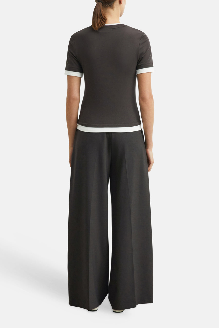Brown wide-leg suit trousers by COMMA, shown from back view with smooth texture and clean lines, paired with dark t-shirt featuring white trim.