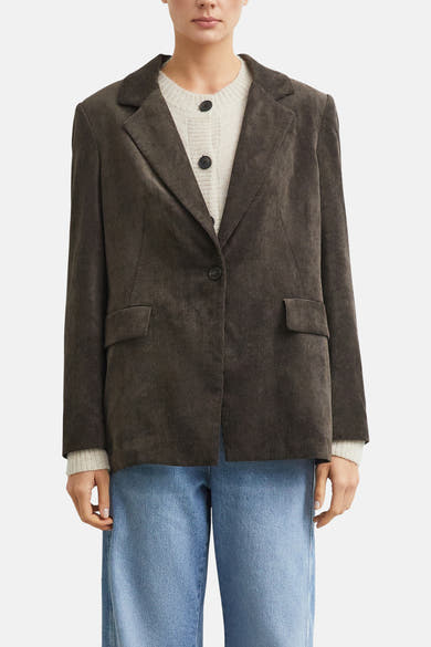 Brown corduroy blazer by COMMA, featuring notched lapels, single-button front, flap pockets, worn over cream ribbed top and blue jeans, front view.